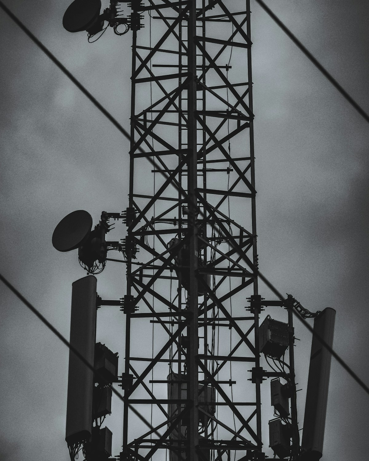 Lattice telecommunications mast with antennas against an overcast sky